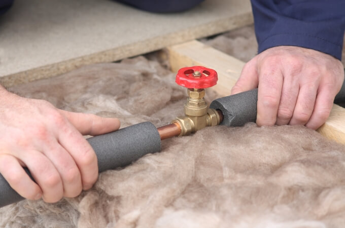 plumber-holding-pipe-on-either-side-of-valve