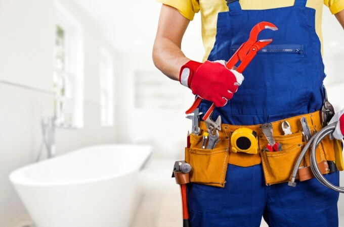 plumber-in-bathroom-holding-red-shifter