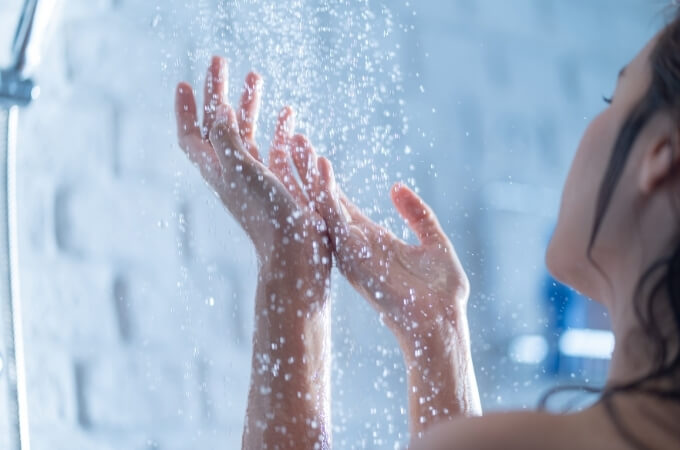 water-saving-shower-heads-in-bathroom-lady-showering-under